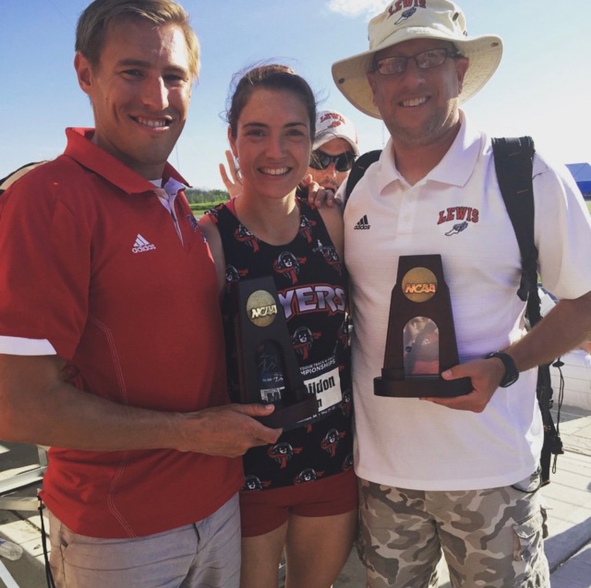 Megan with her coaches holding NCAA All-American trophies