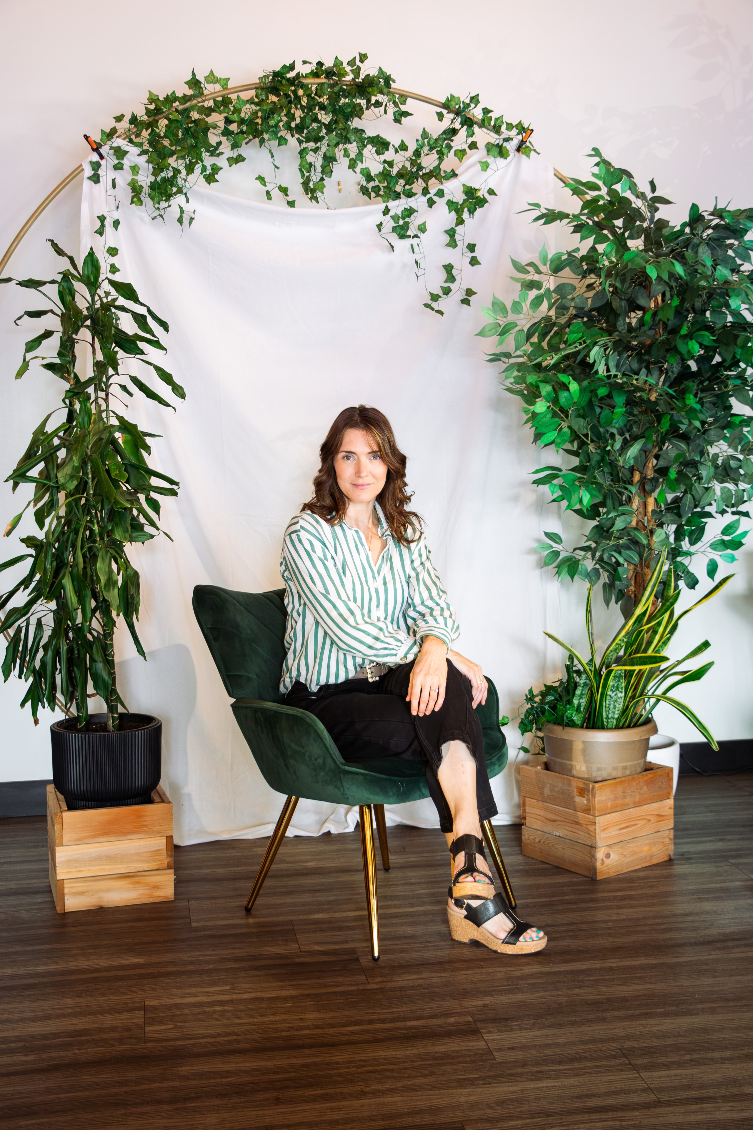 Megan Marchildon seated inside MegaMindful Living surrounded by plants